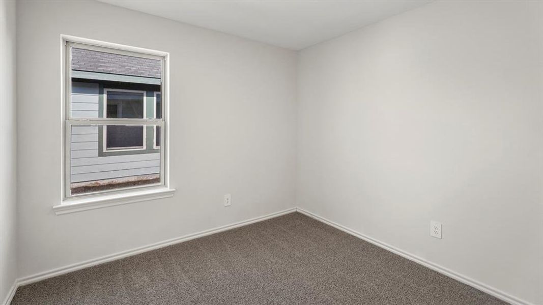 Interior room featuring light gray walls, gray carpet, white trim, and a white-framed window
