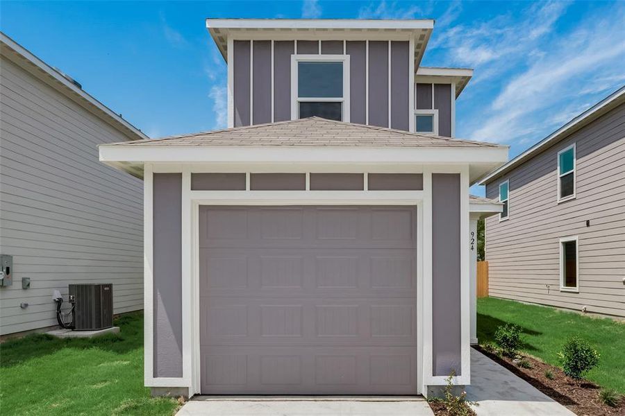 Garage featuring cooling unit and a lawn