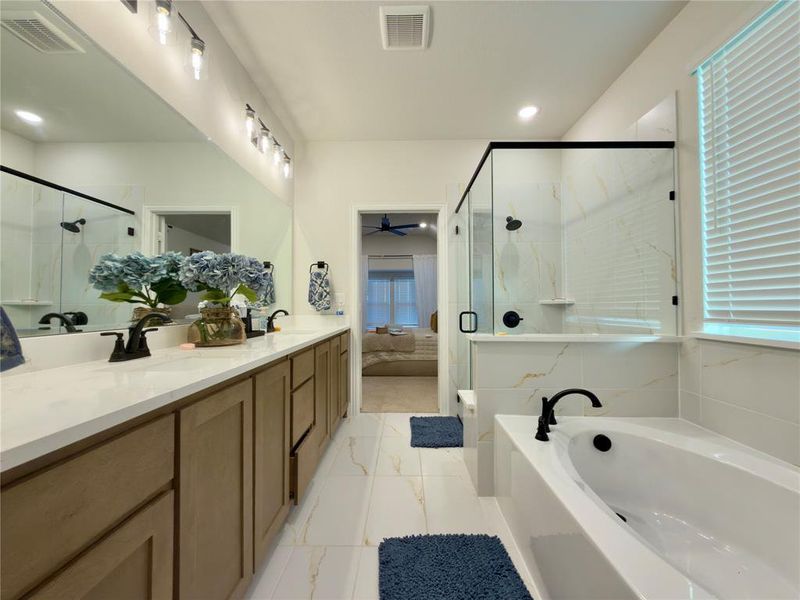 Full bath with double vanity, a marble finish shower, a garden tub, ceiling fan, and recessed lighting