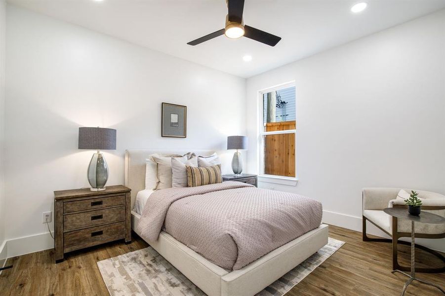 Bright room featuring wood-finish flooring, recessed lighting, and a contemporary ceiling fan Bright room featuring wood-finish flooring, recessed lighting, and a contemporary ceiling fan
