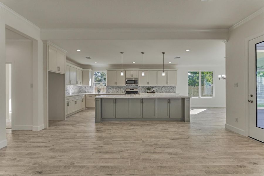 Stunning view from the den into the chef's kitchen. Note: the exterior door access to the covered patio. Stunning view from the den into the chef's kitchen. Note: the exterior door access to the covered patio.