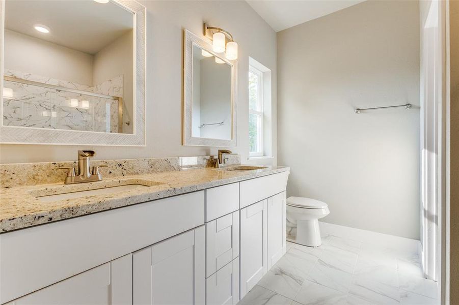 Bathroom with tile patterned flooring, vanity, toilet, and walk in shower