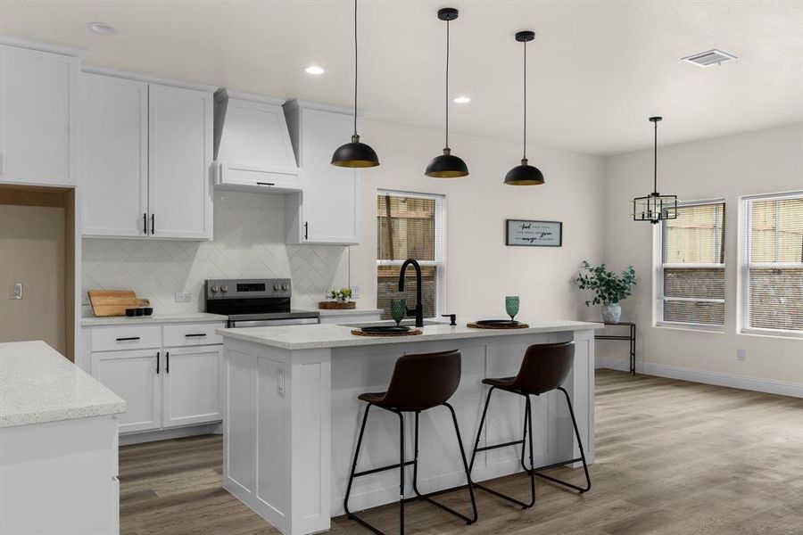 Kitchen featuring pendant lighting, sink, custom range hood, a center island with sink, and electric stove