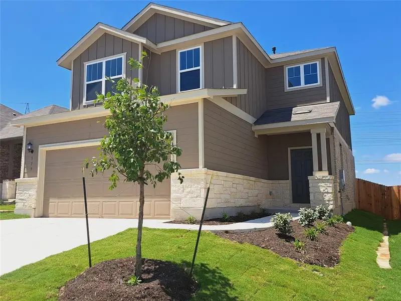 Front exterior of a new home in Sunfield, Buda, TX, highlighting curb appeal (Image 2). Front exterior of a new home in Sunfield, Buda, TX, highlighting curb appeal (Image 2).
