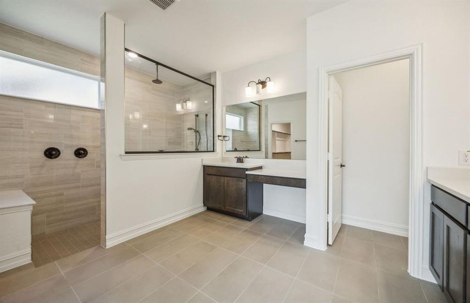 Elegant owner's bathroom with dual vanity and oversized shower *real home pictured