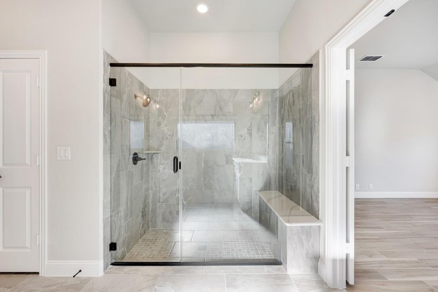 Large walk-in shower with glass doors, marble tile walls, and built-in bench seat Large walk-in shower with glass doors, marble tile walls, and built-in bench seat