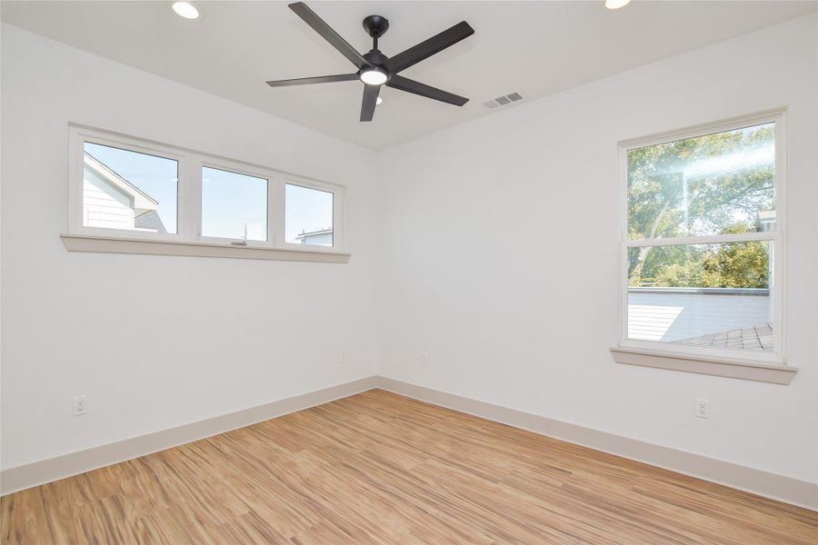 View of headboard wall plus additional window. Lots of natural light but w/privacy from the front street.