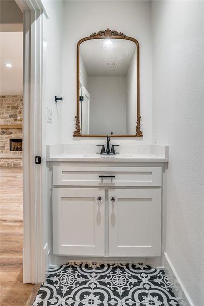 Bathroom featuring hardwood / wood-style flooring, vanity, and a fireplace