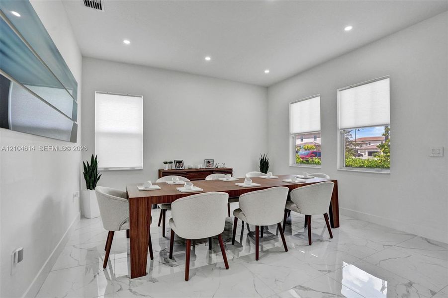 Spacious room featuring glossy white tile flooring, recessed lighting, and multiple windows