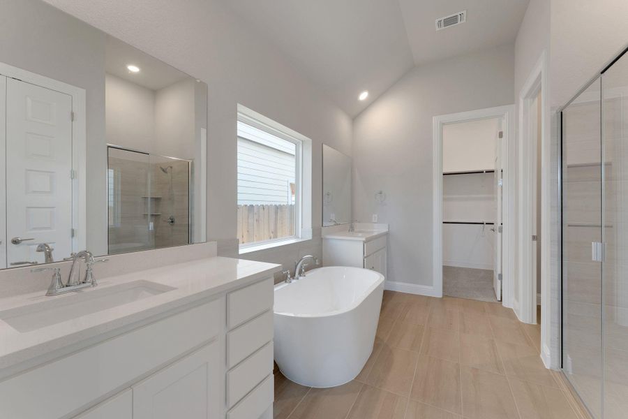 Full bath featuring a shower stall, vanity, a soaking tub, a walk in closet, and recessed lighting Full bath featuring a shower stall, vanity, a soaking tub, a walk in closet, and recessed lighting