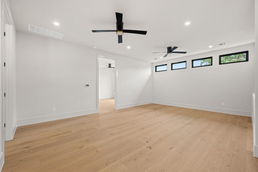 Gleaming hardwood floors and clean geometric windows highlight this versatile upstairs living space.