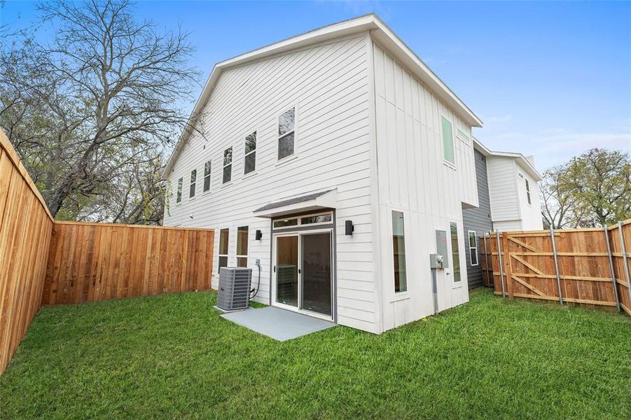 Rear view of house featuring a fenced backyard, a gate, and a patio area Rear view of house featuring a fenced backyard, a gate, and a patio area