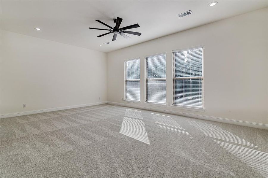 Carpeted spare room featuring ceiling fan