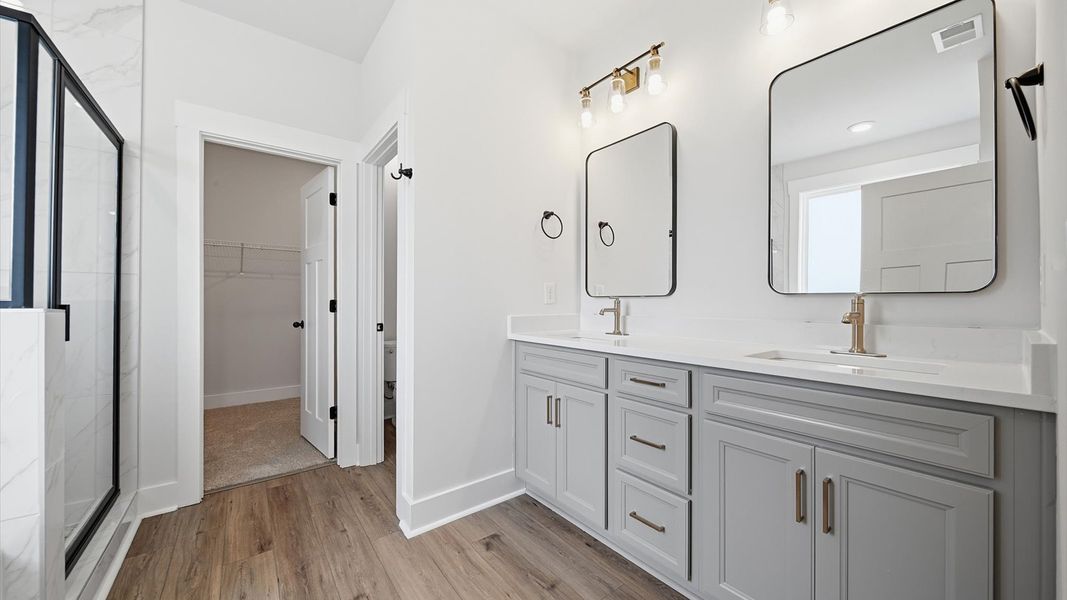 Memorable mornings begin in this elegant primary bathroom with walk-in shower and double vanity in Woodruff, SC