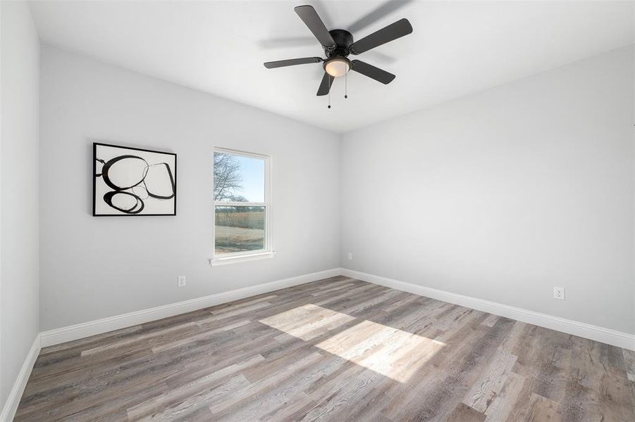 Spare room with ceiling fan and light wood-type flooring