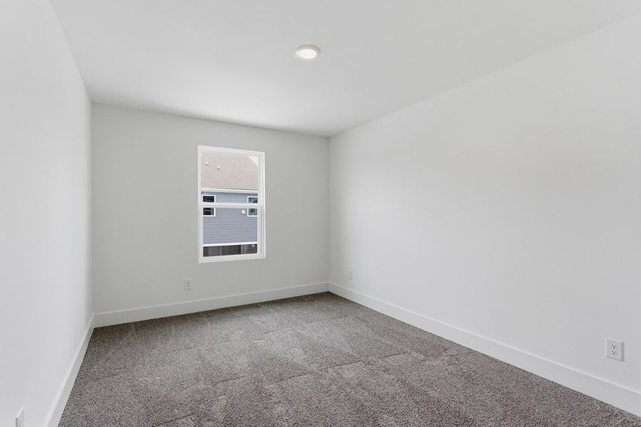 A room with a window and a carpet.