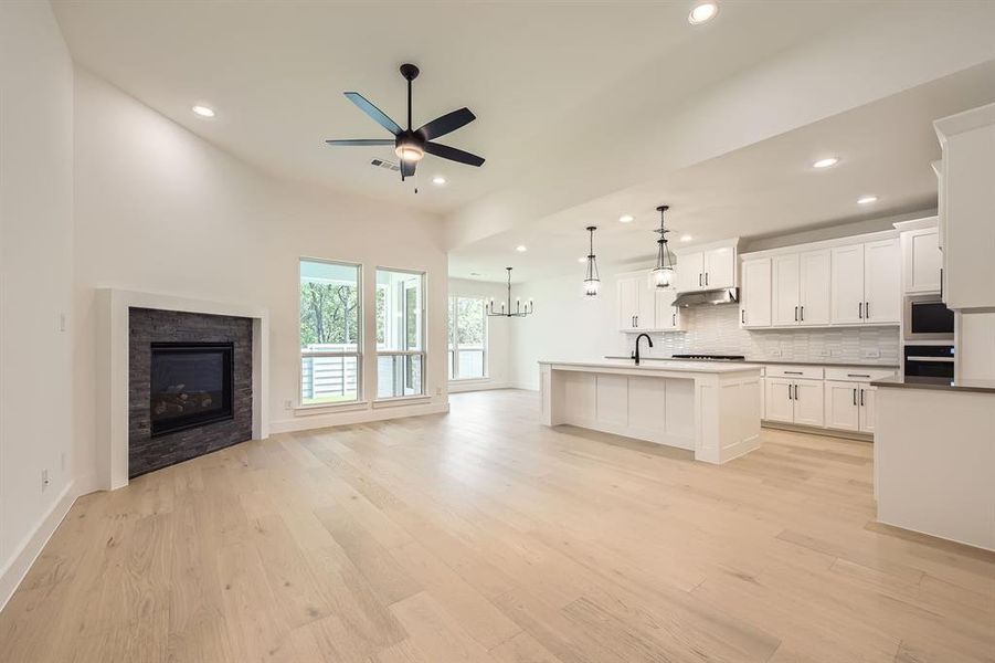 Kitchen with open floor plan, wall oven, a ceiling fan, recessed lighting, and tasteful backsplash