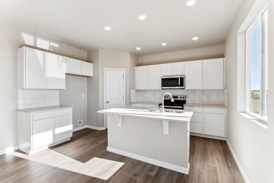 A kitchen with white cabinets.