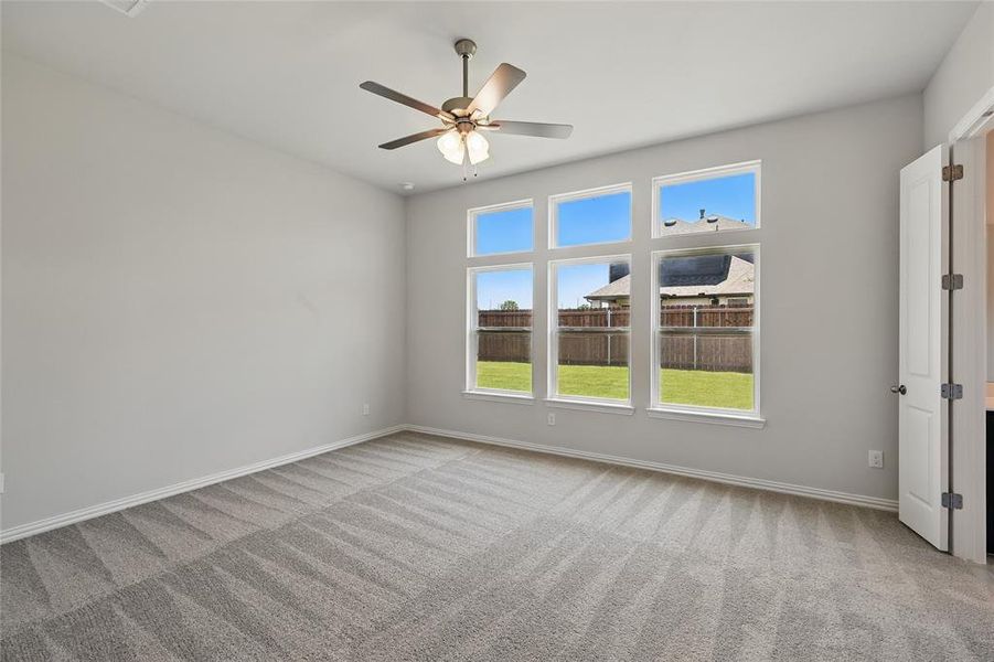 Empty room with carpet flooring, ceiling fan, and baseboards