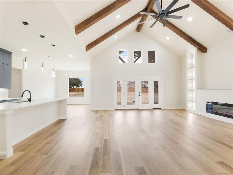 Unfurnished living room featuring a glass covered fireplace, light wood-type flooring, recessed lighting, and ceiling fan