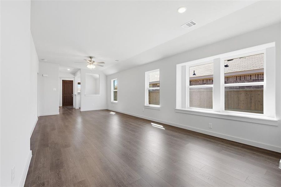 Empty room featuring dark wood finished floors, ceiling fan, and recessed lighting