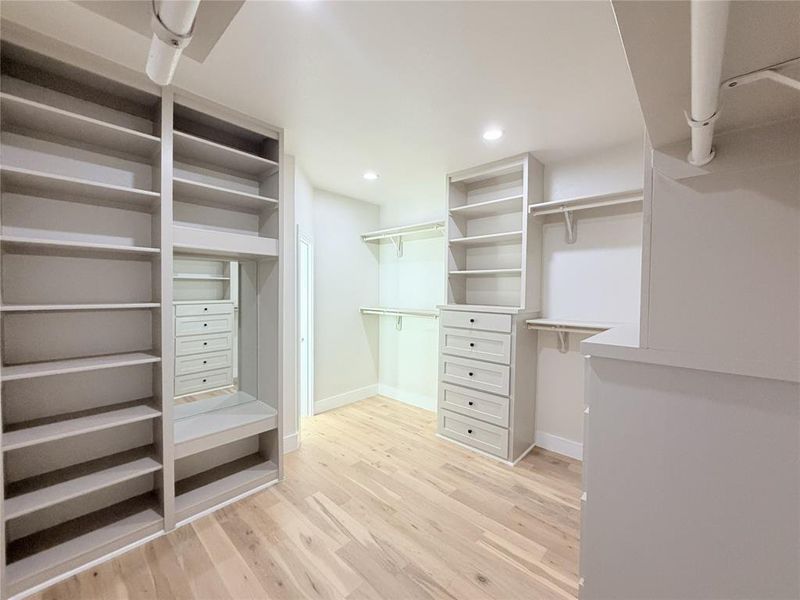 Walk in closet featuring light wood-type flooring Walk in closet featuring light wood-type flooring