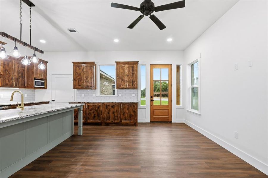 Open-concept living space featuring wood-finish flooring, a contemporary ceiling fan, and recessed lighting Open-concept living space featuring wood-finish flooring, a contemporary ceiling fan, and recessed lighting