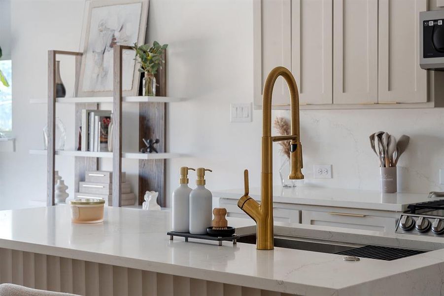 Kitchen island with a gold-finish gooseneck faucet and an undermount sink