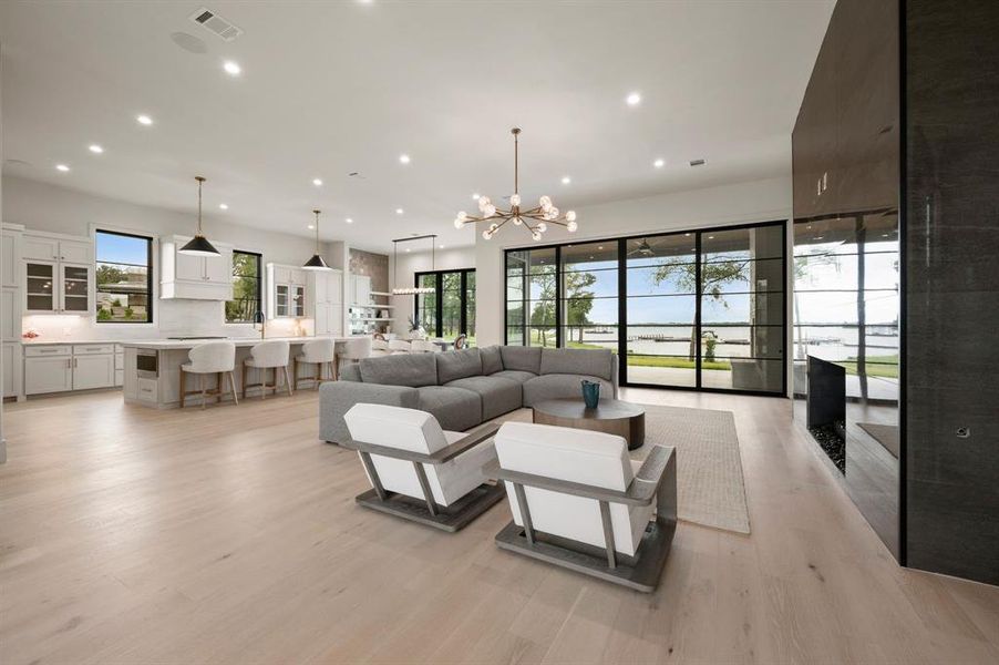 Living area with recessed lighting, a chandelier, and light wood-type flooring Living area with recessed lighting, a chandelier, and light wood-type flooring