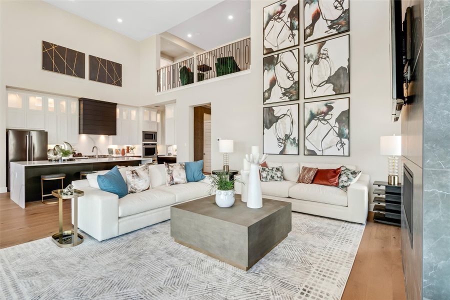 Living area featuring light wood-type flooring and a high ceiling Living area featuring light wood-type flooring and a high ceiling