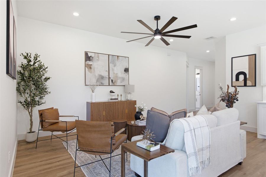 A living area with warm wood flooring and a statement ceiling fan awaits. A living area with warm wood flooring and a statement ceiling fan awaits.
