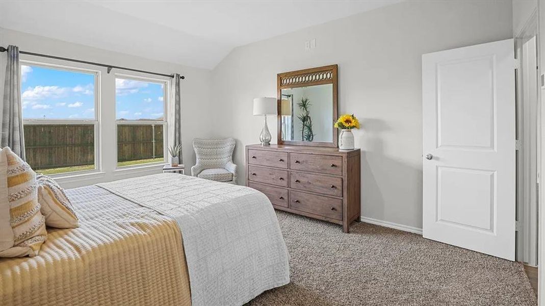 Carpeted bedroom with lofted ceiling