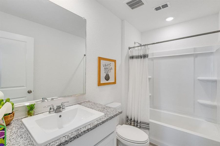 Bathroom with shower / bath combo with shower curtain and vanity