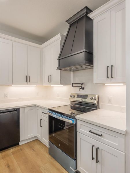 Elevate your culinary experience with this sleek stainless steel electric range, flanked by soft-close white cabinetry and topped with a stunning matte black custom range hood—creating a bold contrast that feels both modern and timeless. Elevate your culinary experience with this sleek stainless steel electric range, flanked by soft-close white cabinetry and topped with a stunning matte black custom range hood—creating a bold contrast that feels both modern and timeless.