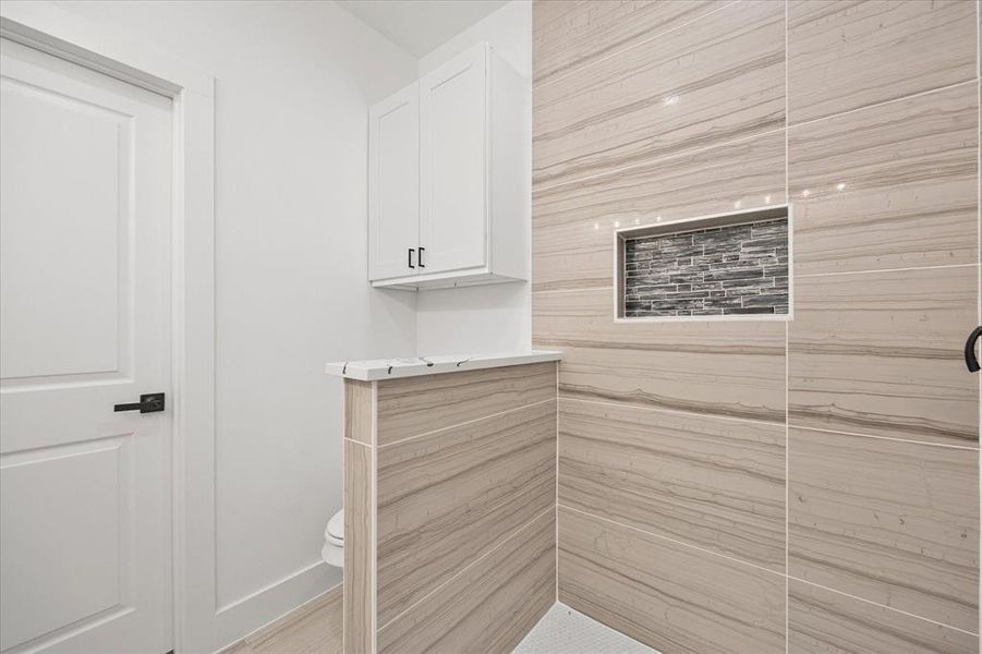 Bathroom view of toilet and a tile shower