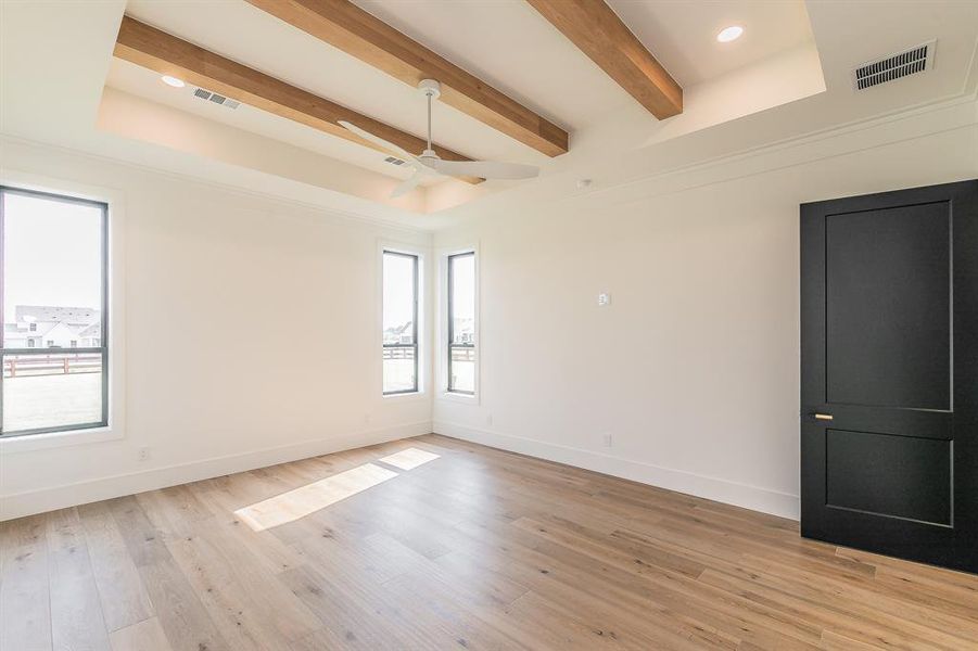 Spare room featuring a ceiling fan, light wood finished floors, beamed ceiling, recessed lighting, and a tray ceiling