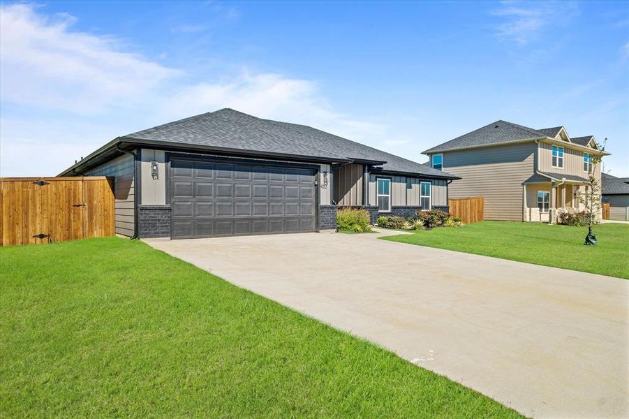 View of front of home with a front lawn and a garage