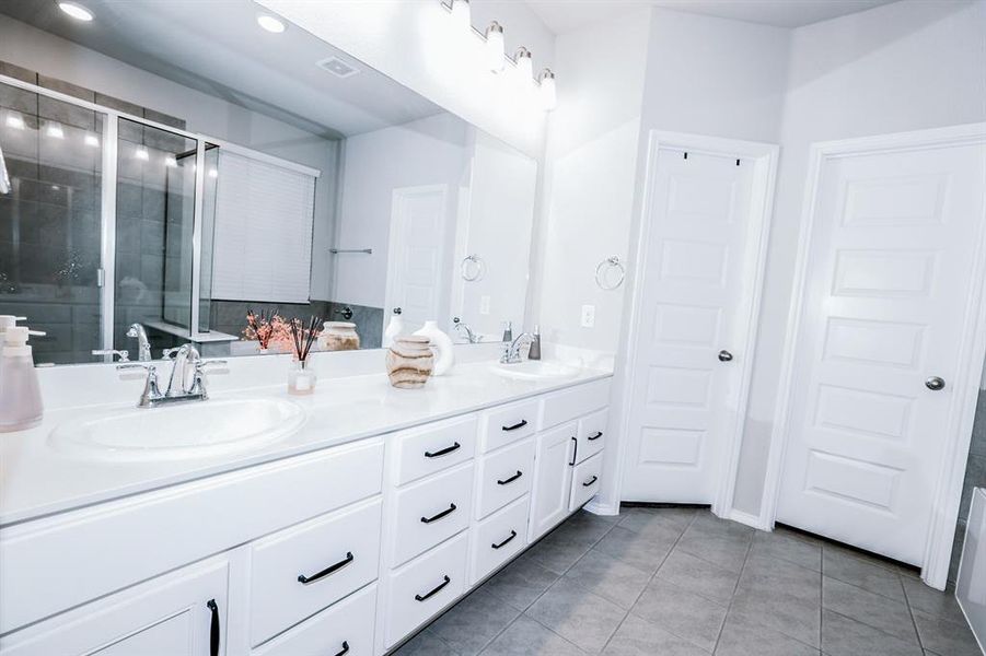 Bathroom with tile patterned flooring, vanity, and an enclosed shower