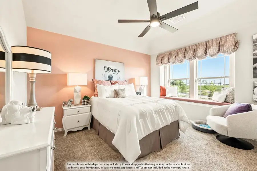 Bedroom with peach accent wall, ceiling fan, window seat, and carpeted floors