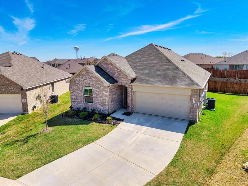 Ranch-style house featuring a garage, concrete driveway, brick siding, a shingled roof, and a residential view Ranch-style house featuring a garage, concrete driveway, brick siding, a shingled roof, and a residential view