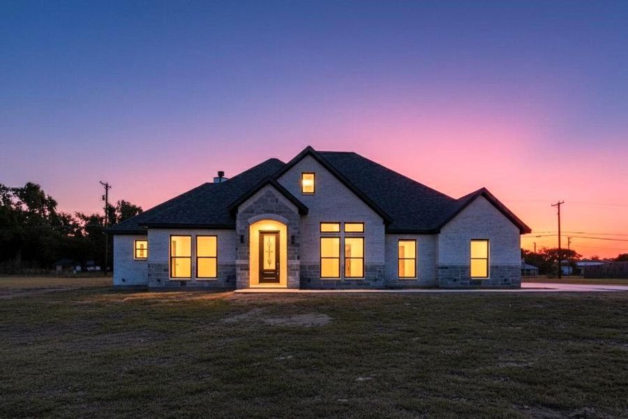 View of front of home featuring stone siding and a front lawn