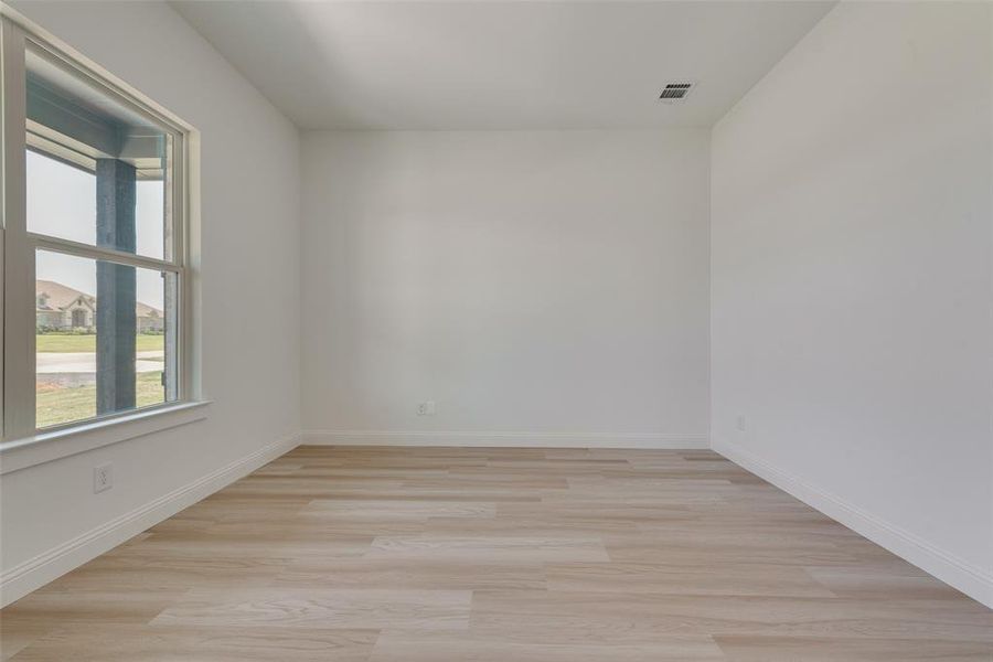 Empty room with light hardwood / wood-style floors