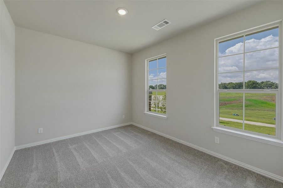 Bright room featuring two large windows, neutral gray carpet, white baseboards, and a recessed ceiling light Bright room featuring two large windows, neutral gray carpet, white baseboards, and a recessed ceiling light