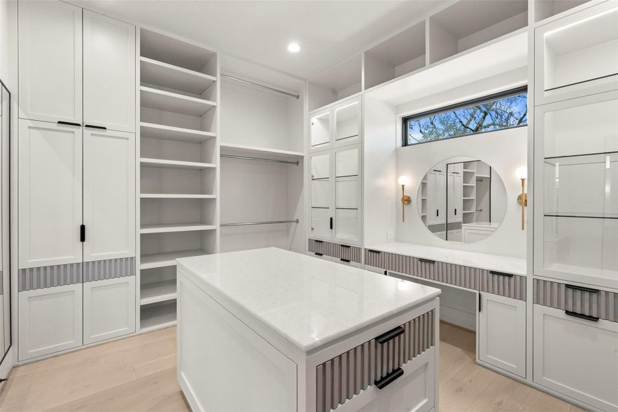 Custom luxury walk-in closet featuring built-in cabinetry, and a center island with additional storage. Designed with clean lines and high-end finish. Custom luxury walk-in closet featuring built-in cabinetry, and a center island with additional storage. Designed with clean lines and high-end finish.