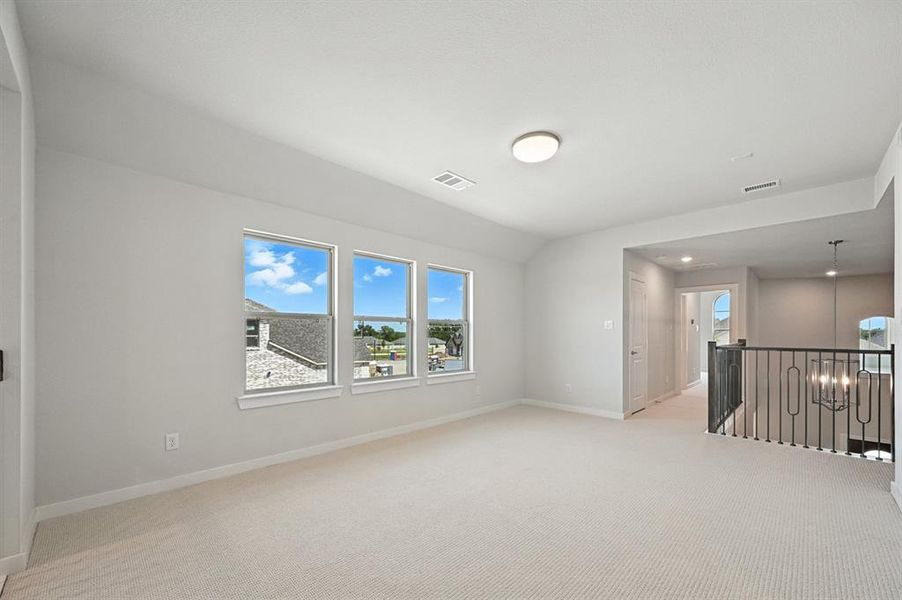 Spare room featuring light carpet and lofted ceiling Spare room featuring light carpet and lofted ceiling