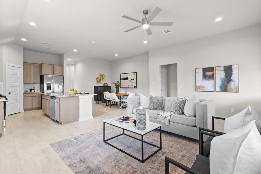 Spacious open-concept living area connects the kitchen, dining, and family room beneath high ceilings with recessed lighting and a modern ceiling fan. Spacious open-concept living area connects the kitchen, dining, and family room beneath high ceilings with recessed lighting and a modern ceiling fan.