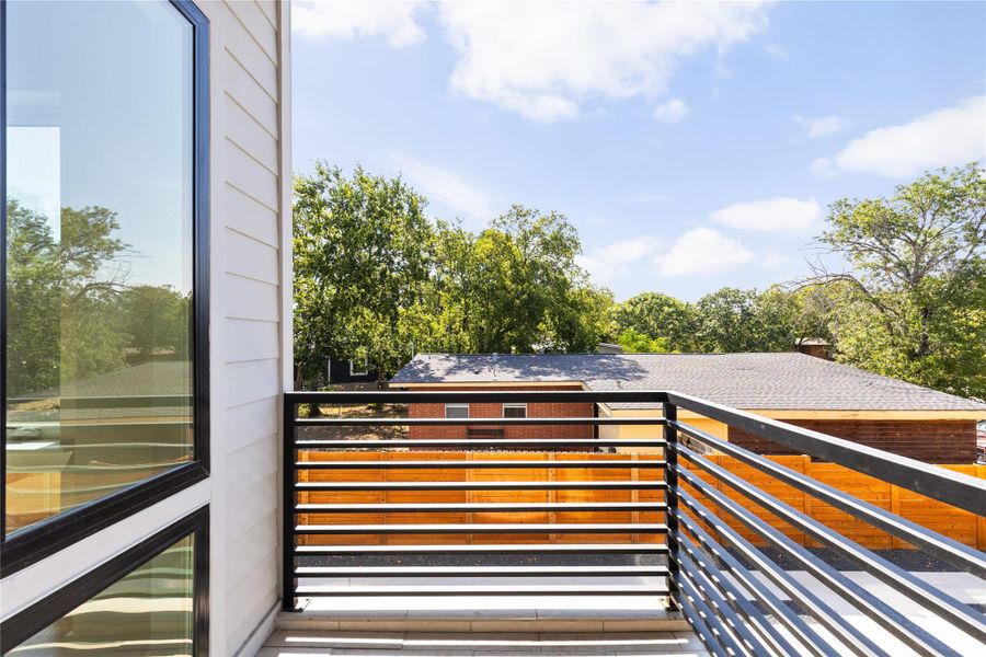 An elevated perspective overlooks the surrounding neighborhood from this sleek metal-railed balcony.