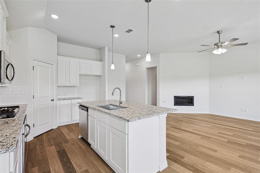 Kitchen featuring dark hardwood / wood-style flooring, sink, decorative backsplash, lofted ceiling, and white cabinets