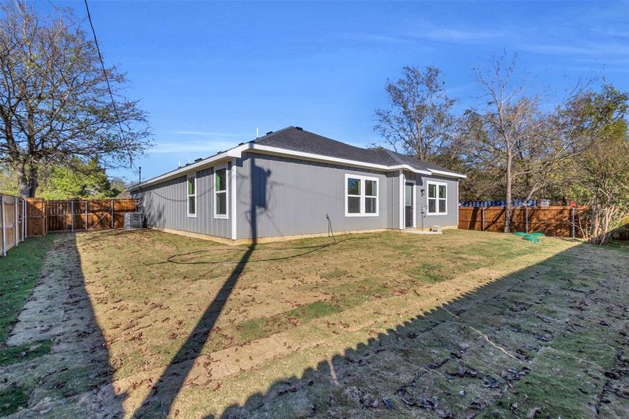 Rear view of house featuring a fenced backyard