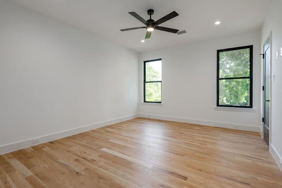 Bedroom with ceiling fan and light hardwood floors